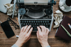 hands-creating-content-on-a-typewriter