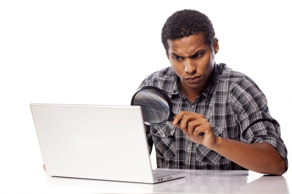 Looking at laptop with a magnifying glass