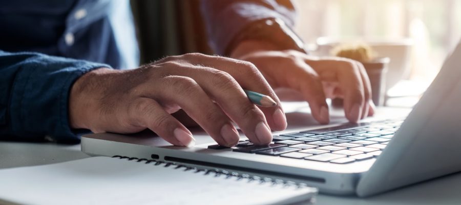 A man writing content on a computer.