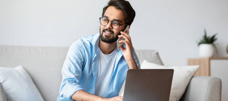 Happy Man On Laptop & Phone Getting Good Customer Service